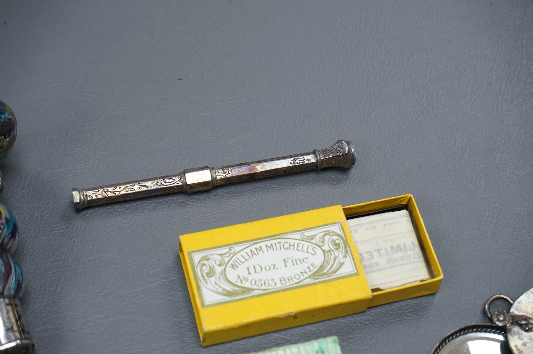 A small collection of objects to include a 17th century? French multi-cane glass seal, miniature white metal mirror and boxed pen nibs, seal 8cm high